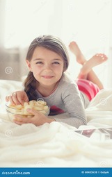 thumbnail of little-girl-eating-popcorn-bed-beautiful-years-old-brunette-long-hair-braided-braid-dressed-gray-t-shirt-68483638-3614944582.jpg