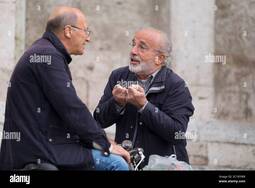 thumbnail of two-italian-men-talk-to-each-other-and-make-typical-italian-gestures-on-the-square-piazza-del-popolo-in-ascoli-piceno-italy-2C1RYW9.jpg