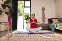 thumbnail of Non-binary trans woman practicing yoga and meditation sitting on yoga mat at home.png