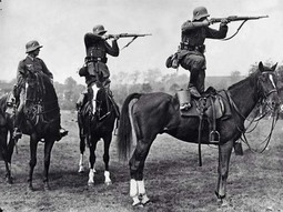 thumbnail of German soldiers take aim from the backs of horses, mid-1930.jpg