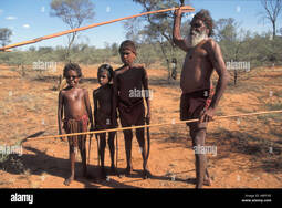 thumbnail of aboriginal-elder-teaching-young-boys-to-hunt-points-to-animal-dropping-A8PC6E.jpg